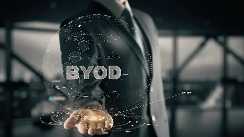 Hologramme BYOD affichant des données technologiques et une main lumineuse symbolisant la gestion mobile en entreprise.